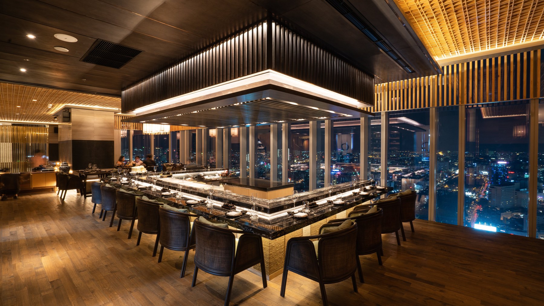 Towa's counter at night — city lights through the floor-to-ceiling windows