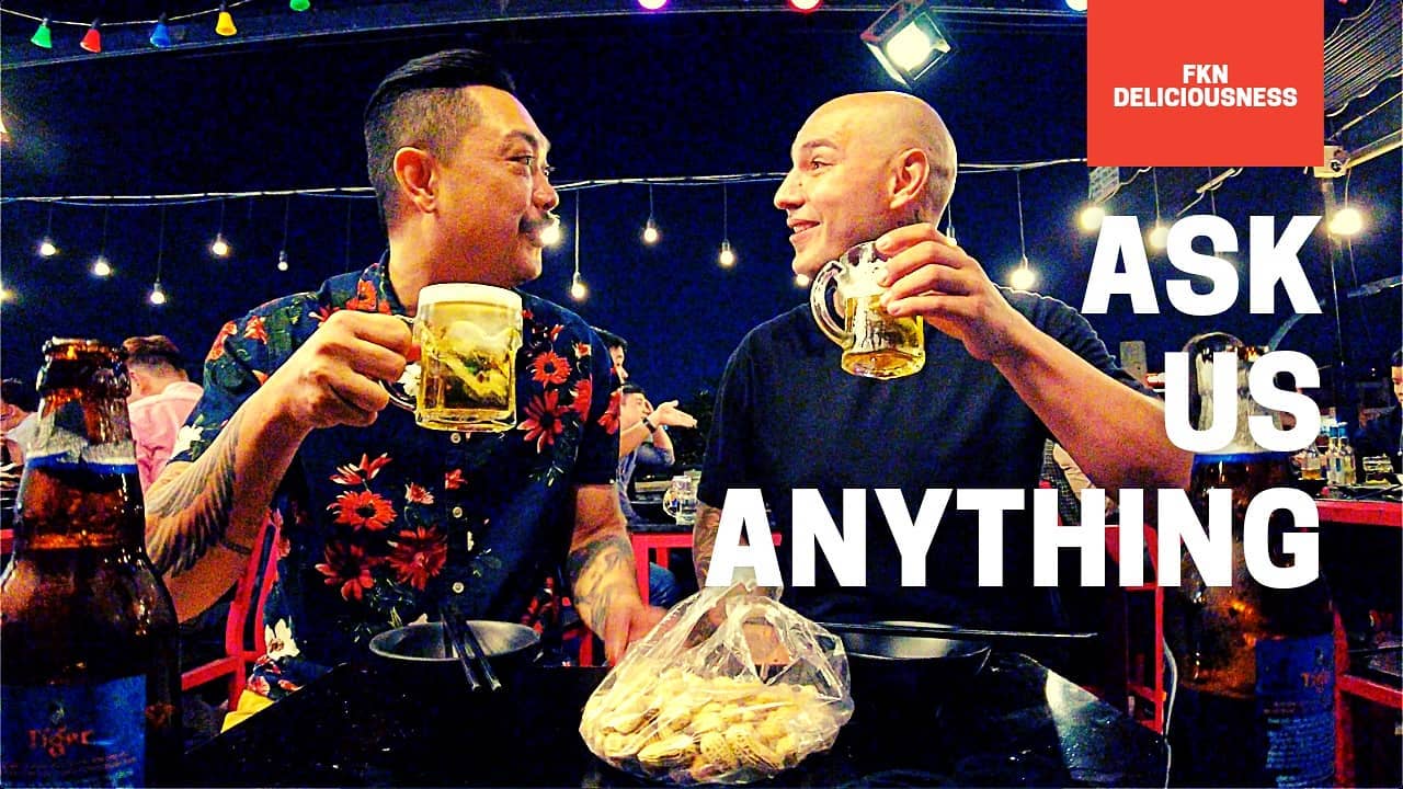 Two friends toasting beer under night string lights