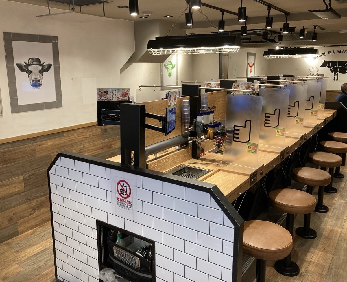Yakiniku Like interior: dark room, lit grill counters