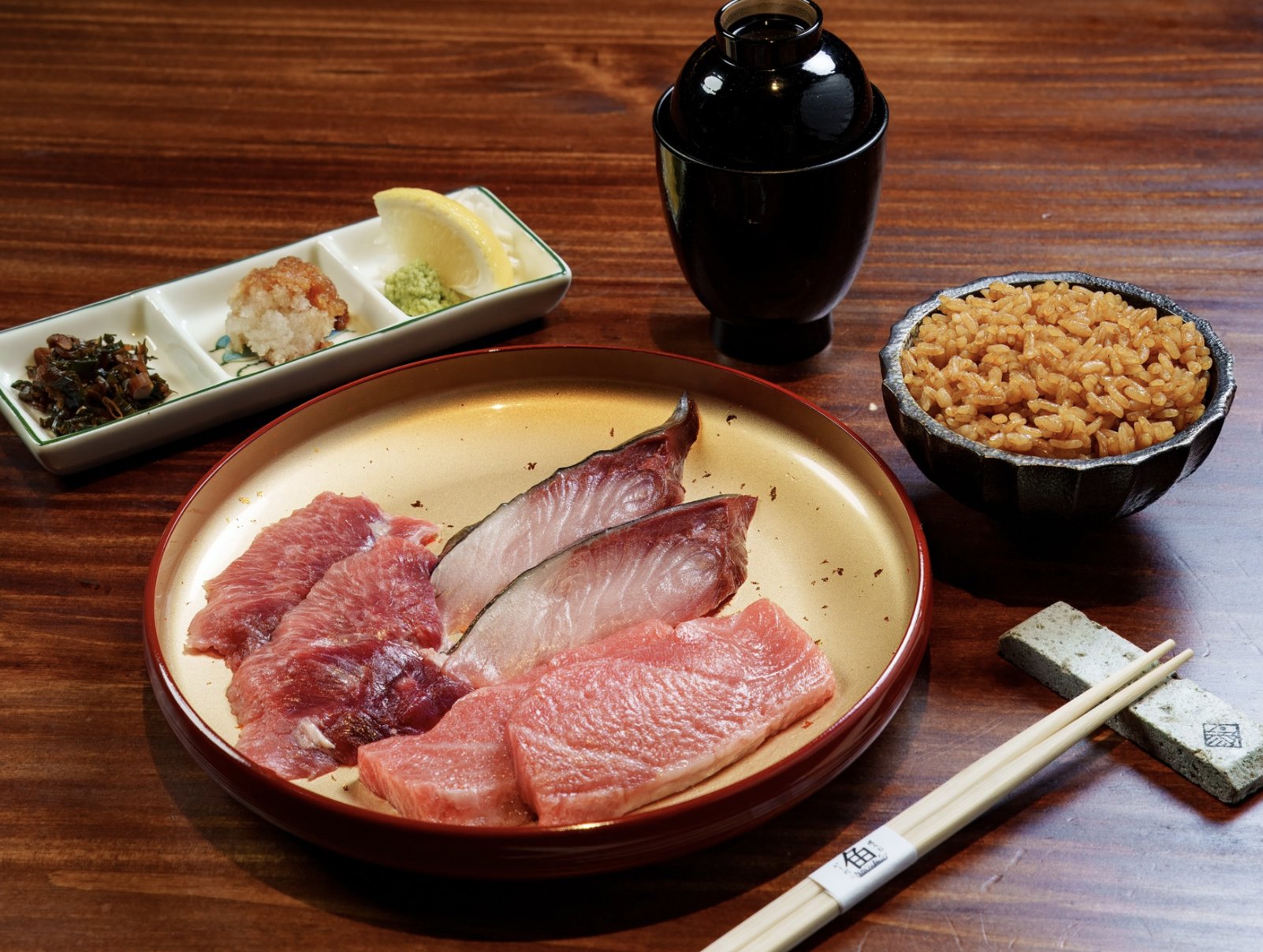 Đĩa sashimi cùng đũa có logo của quán