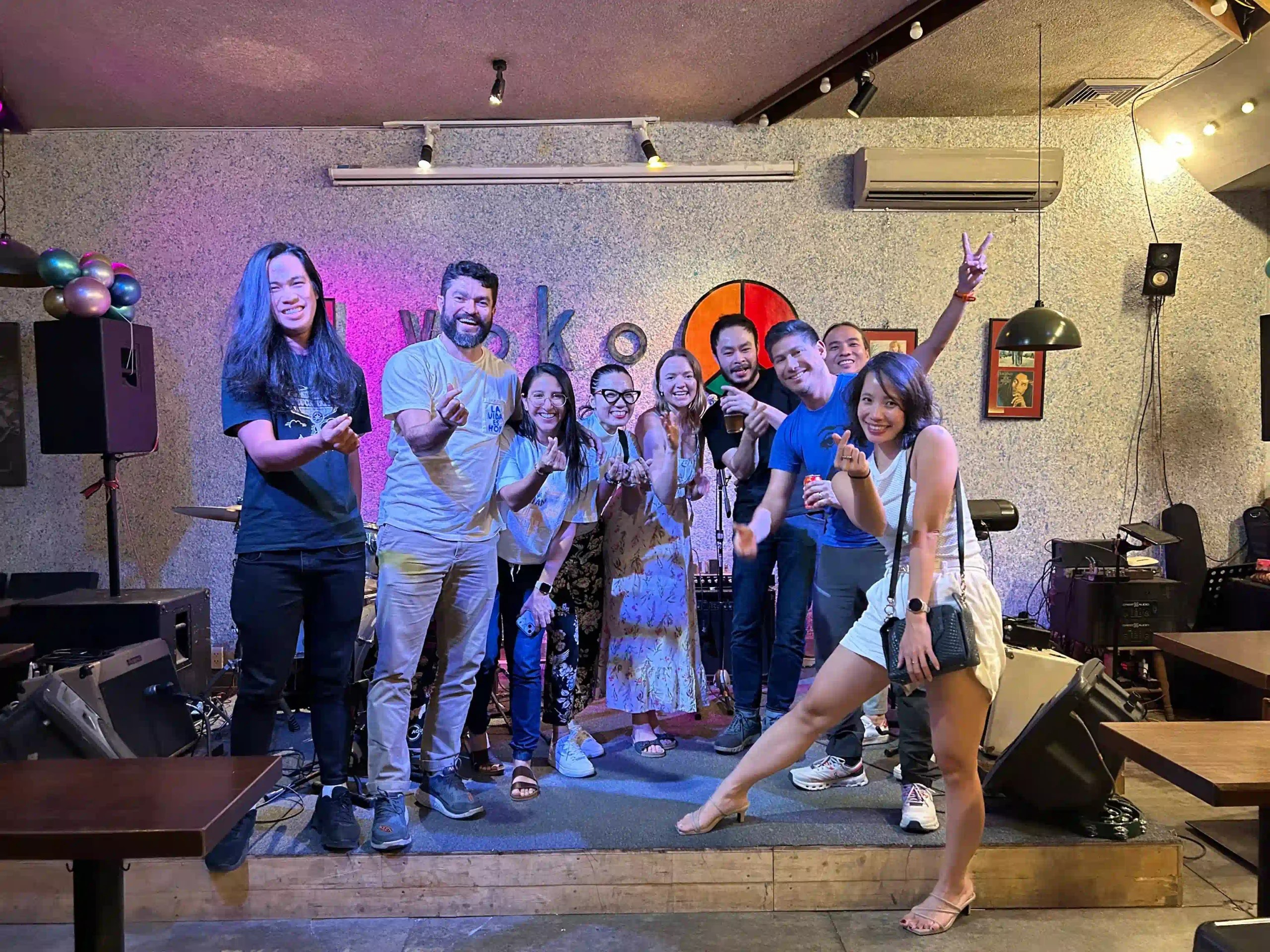 Yoko — friends posing on stage under purple lights