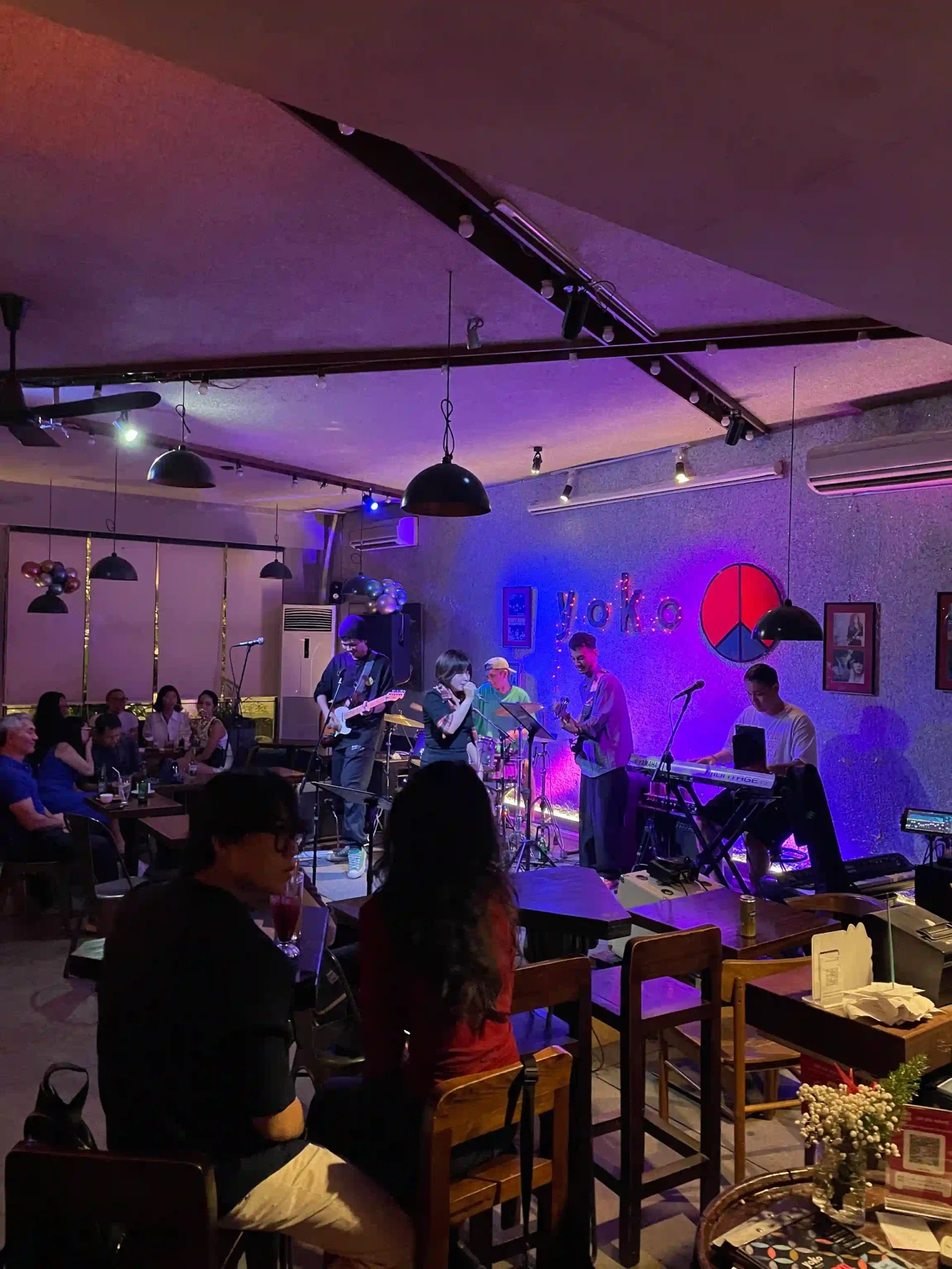 Yoko — ban nhạc live dưới đèn sân khấu tím, bảng yoko phát sáng