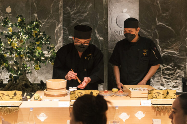 Two chefs behind the counter with the yuzu tree