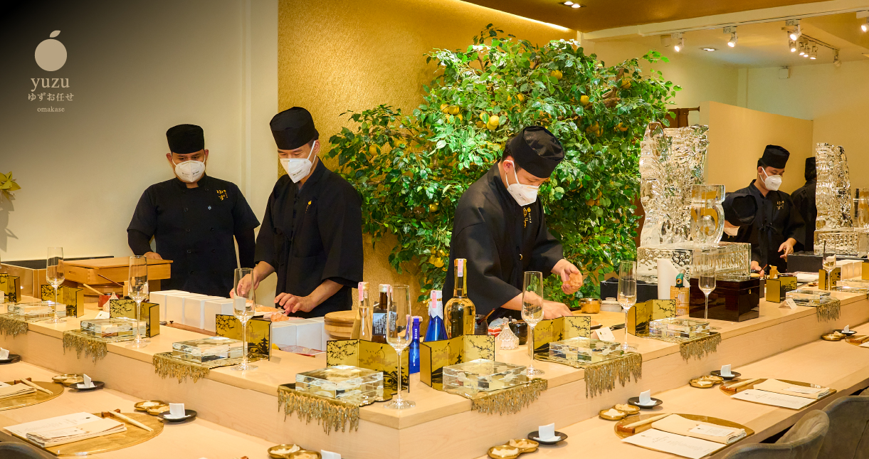 Chefs preparing dishes along the long counter